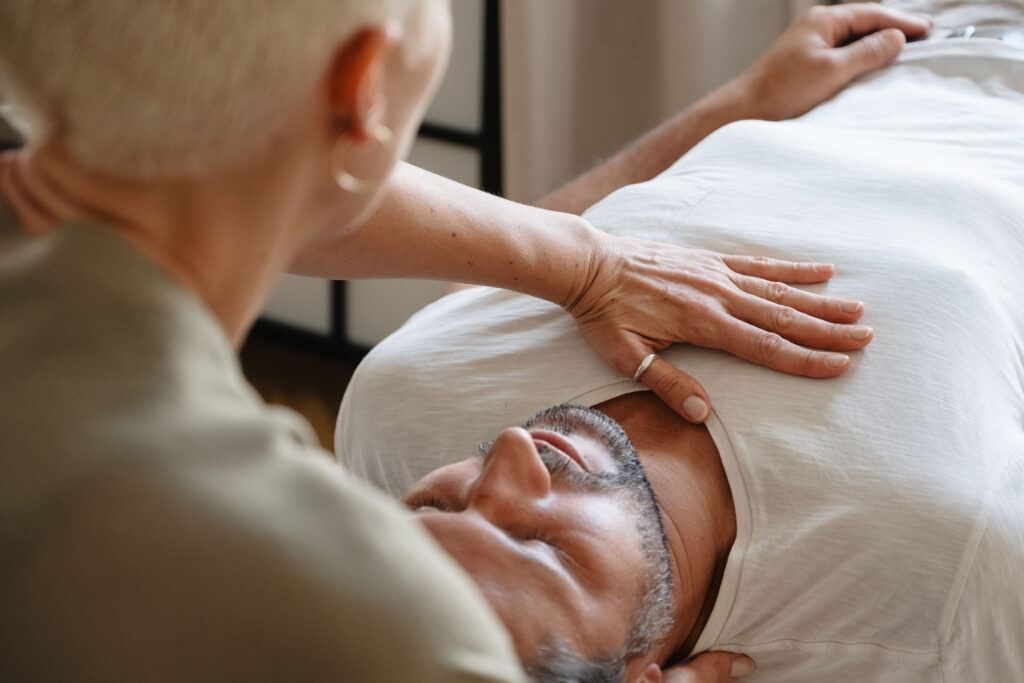 Nahaufnahme: Mann liegt entspannt, Hände ruhen sanft auf seiner Brust