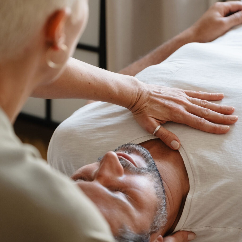 Sanfte Körperarbeit in Traisen – Hände ruhen achtsam auf der Brust eines Klienten